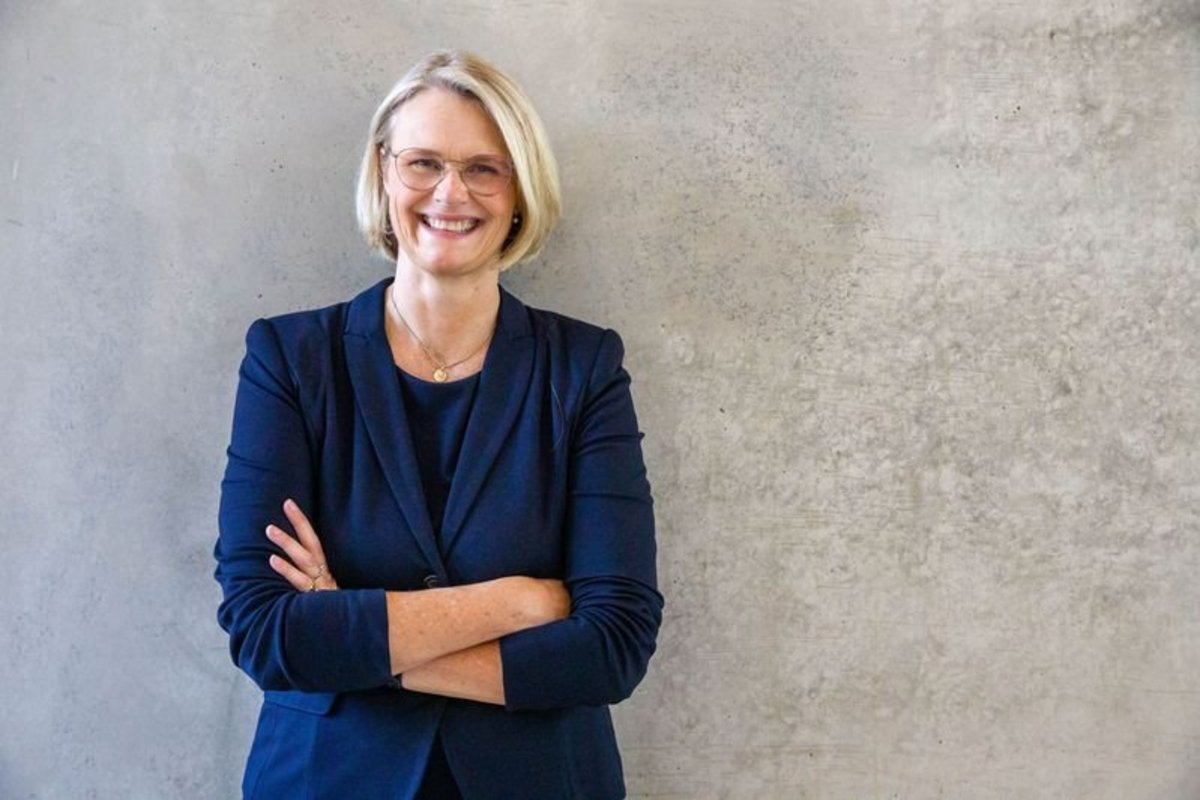 blone lächelnde Frau im blauen Anzug